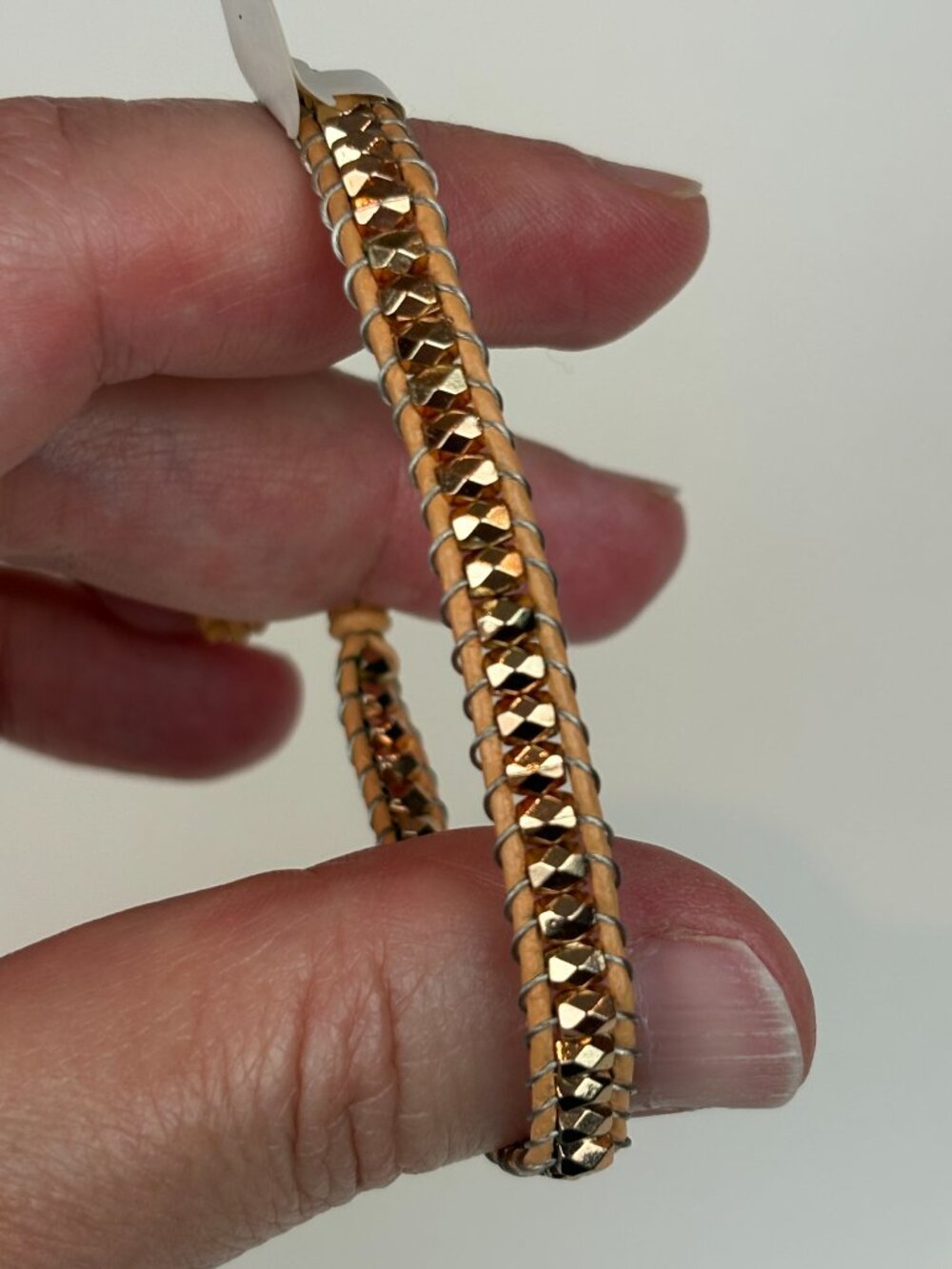 Express shimmering rose gold tone beaded leather wrap bracelet. New with tags